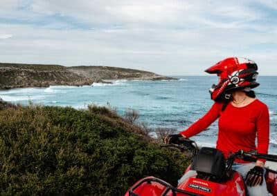 Guest riding red Honda quad bike during Edge of the Earth Quad Bike Tour at Cape Kersaint on Kangaroo Island