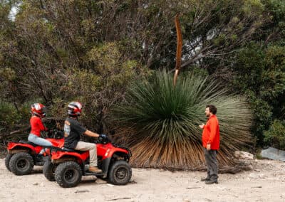 Guide sharing interpretation beside a native yacca plant during a guided quad bike tour at Kangaroo Island Outdoor Action, South Australia